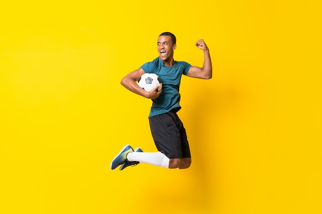 Фото Афро-американский футболист человек над желтой стеной