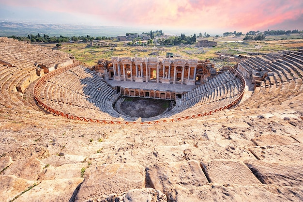 Amphitheater in ancient city of Hierapolis under dramatic pink sky