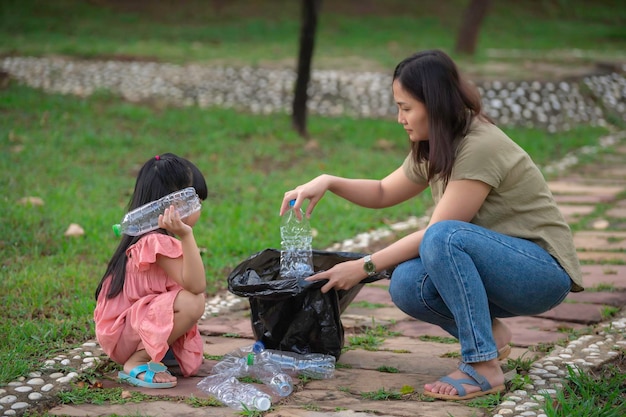 Азиатская мать и дочь помогают благотворительной организации по сбору мусора