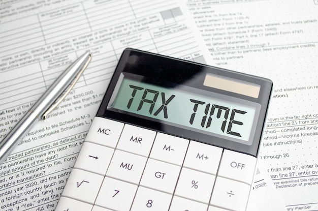 Photo ax time word on calculator business and tax concept time to pay tax in year