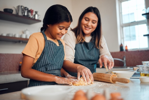 Photo baking family and love with a daughter and mother teaching a girl about cooking baked goods in a kitchen food children and learning with an indian woman and girl together in their home to bake