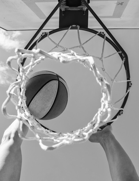 Фото Мяч проходит через корзину, мужчина бросает мяч в обруч и играет в баскетбол