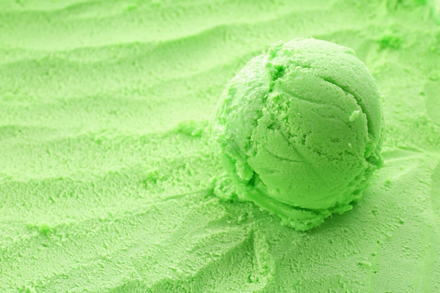 Шарик мороженого на зеленом текстурированном фоне