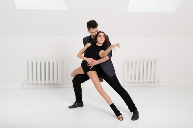 Photo beautiful couple dancing bachata on white background in studio