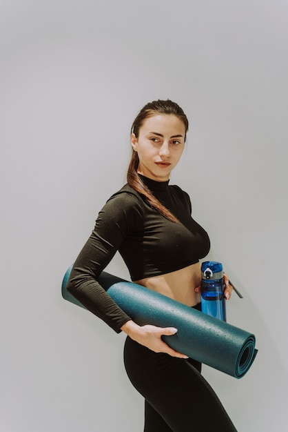 Фото Красивая спортивная женщина тренируется в тренажерном зале, делая упражнения на растяжку перед тренировкой