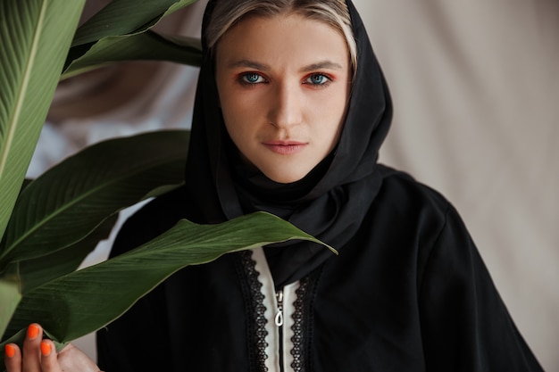 Фото Красивая мусульманская женщина в традиционном арабском платье абая на сером фоне