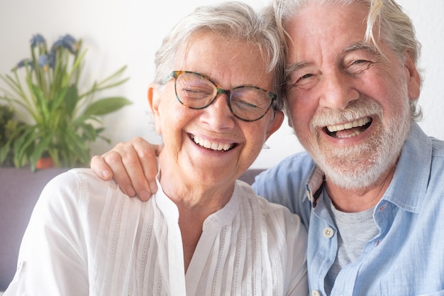 Photo beautiful senior couple having fun and laughing sitting at home on sofa enjoying retirement