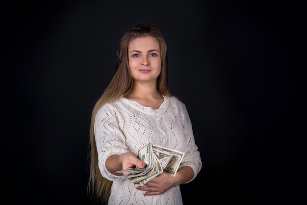 Фото Красивая женщина, предлагающая деньги или взятку, изолирована на черном