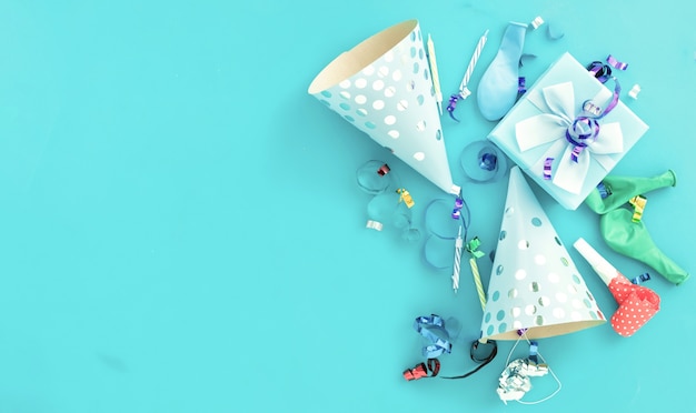 Фото Фон с воздушным шаром на день рождения с подарочной коробкой, красочными лентами для вечеринок, конфетти и шляпами для дня рождения на синем