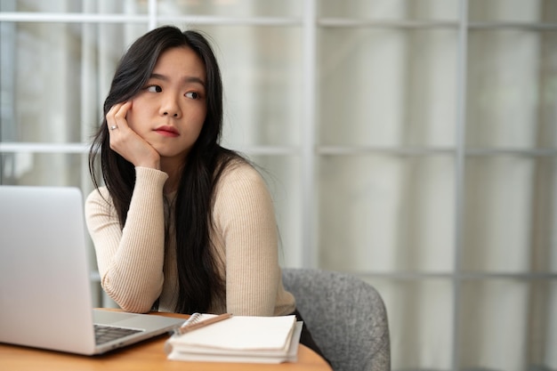 A bored Asian female college student looking away from the camera with a boring face