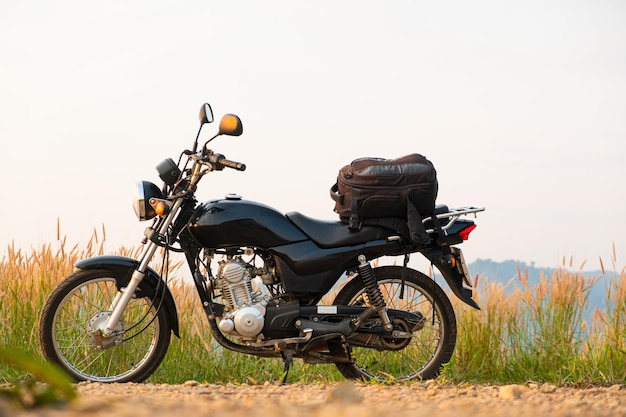 Фото Черный ретро-мотоцикл с рюкзаком, припаркованный на открытом воздухе