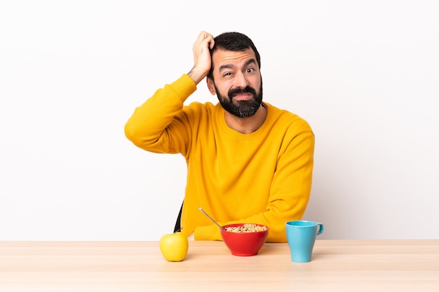 Blanke man aan het ontbijten in een tafel met een uitdrukking van frustratie en niet begripvol.