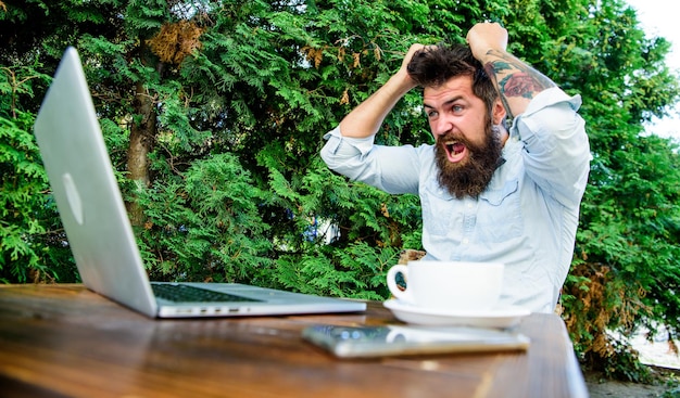 Photo brutal bearded hipster need coffee break frustrated office worker aggressive businessman agile business solve problem deadline a lot of work stressed man working on laptop office life