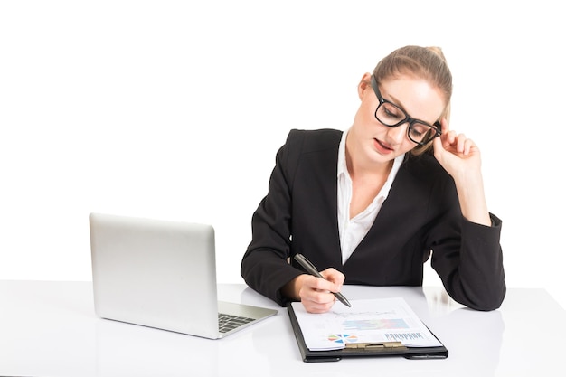Foto donna d'affari che scrive seduta alla scrivania su uno sfondo bianco