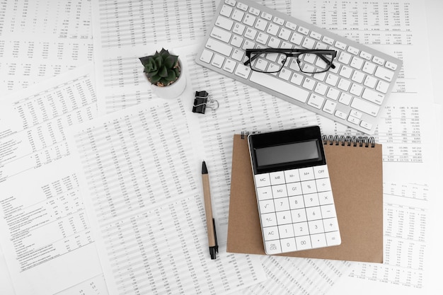Фото Клавиатура калькулятора с увеличительным стеклом и очками, лежащими на финансовых документах финансовая и бизнес-концепция вид сверху