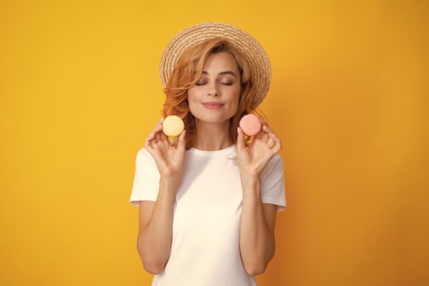 Фото Очаровательная женщина хочет откусить вкусный макарон, держа миндальное печенье рядом с открытым ртом, красавица, наслаждающаяся сладостями