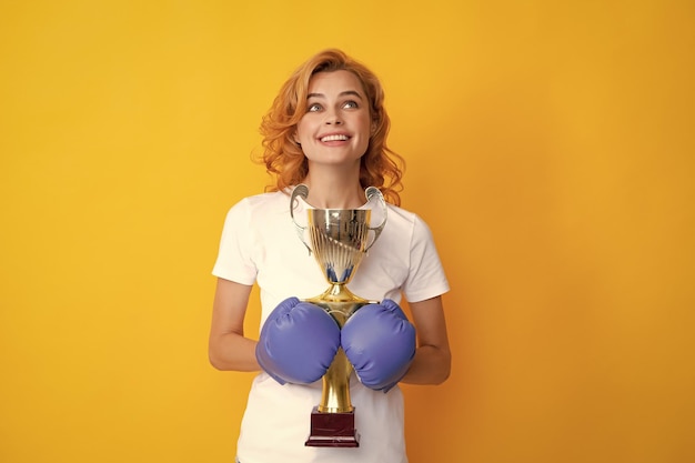 Фото Веселая женщина празднует победу женщина в боксёрских перчатках держит кубок победителя чемпиона
