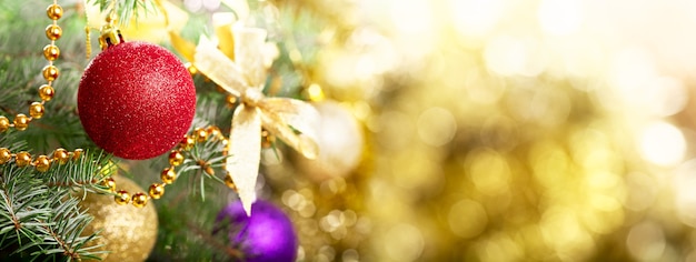 Рождественский фон. Рождественская елка украшена красочными шарами на ветке пихты на размытом фоне