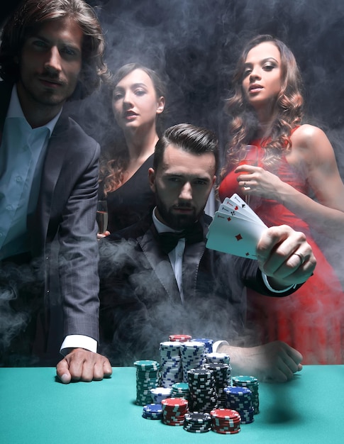 Сконцентрированные мужчины и женщины, играющие в покер в казино