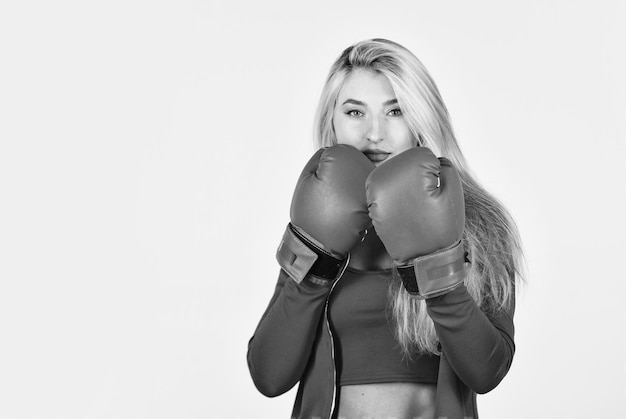 Фото Уверенная в себе молодая спортсменка позирует в боксерских перчатках красивая женщина с красными боксерскими перчатками молодая спортивная женщина в спортивном костюме и боксерские перчатки блондинка боксерка начинает