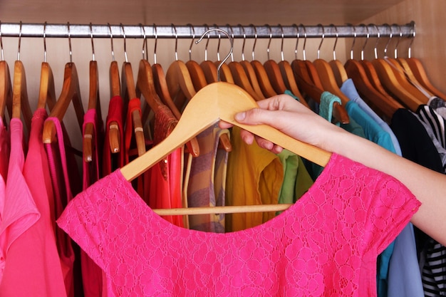Photo colorful clothes hanging in wardrobe
