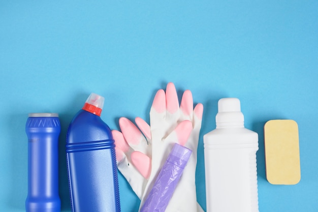 Красочный набор для уборки различных поверхностей на кухне, в ванной. Уборка и концепция генеральной уборки. копирование пространства синий фон губка, перчатки и бутылки с моющим средством