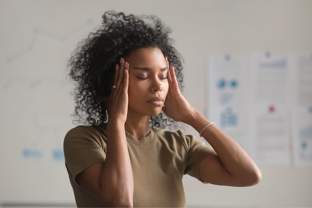Photo close up of exhausted african american woman feel unwell touch massage temples suffer from headache tired black female worker have migraine or dizziness stand with eyes closed health problem concept