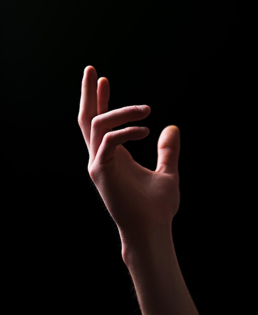 Photo close-up of hand gesturing over black background