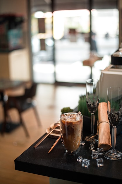 Foto primo piano di caffè ghiacciato servito sul tavolo nero al coffee shop