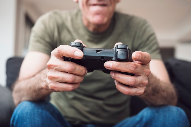 Photo close-up of senior man holding video game console
