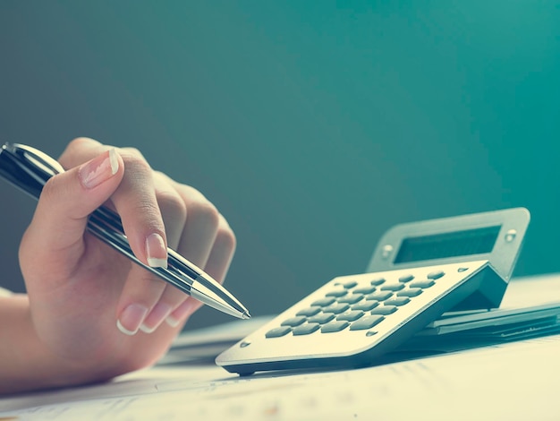 Фото Отрезанные руки деловой женщины, использующей калькулятор с документами за столом