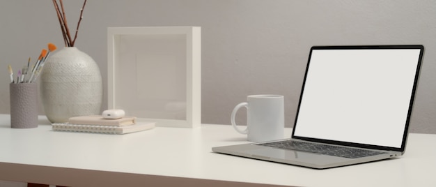 Фото Обрезанный снимок ноутбука с пустым экраном на столе с канцелярскими принадлежностями и украшениями в комнате домашнего офиса