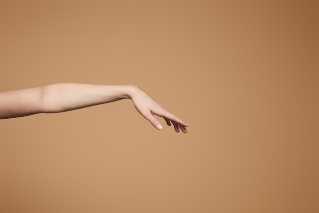 Foto vista ritagliata della mano delicata femminile isolata sul beige