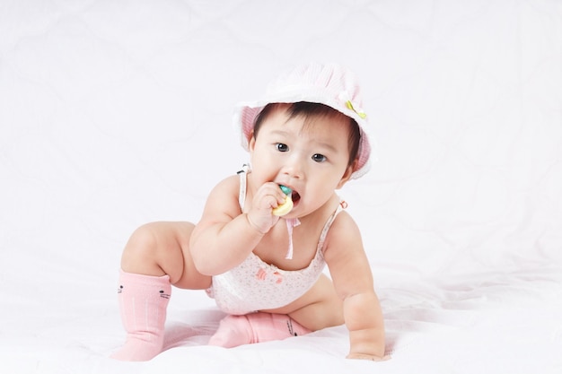 Photo cute baby girl sitting on bed at home