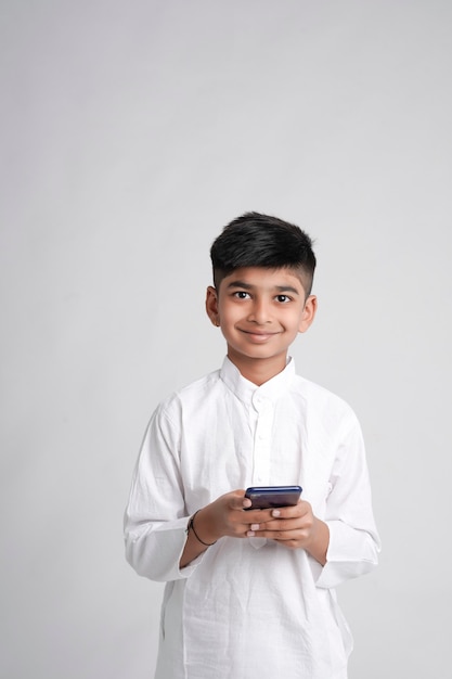 Милый индийский маленький мальчик с помощью смартфона