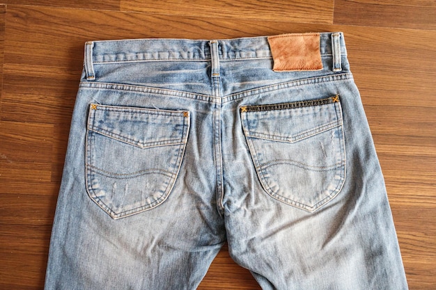 Foto jeans blu denim con etichetta in pelle vuota su fondo in legno