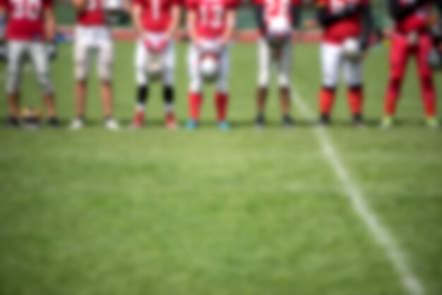 Photo defocused image of american football players standing on field