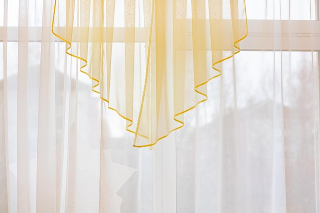 Photo delicate yellow tulle on the window room decor