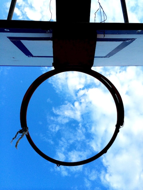 Фото Прямо под выстрелом баскетбольного гола кольцо против неба