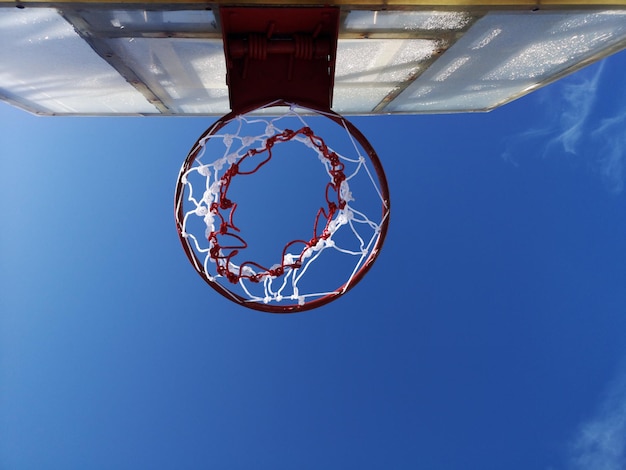 Фото Прямо под выстрелом баскетбольного кольца против голубого неба