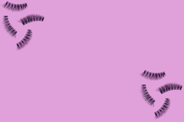 Photo directly above shot of false eyelashes on pink background