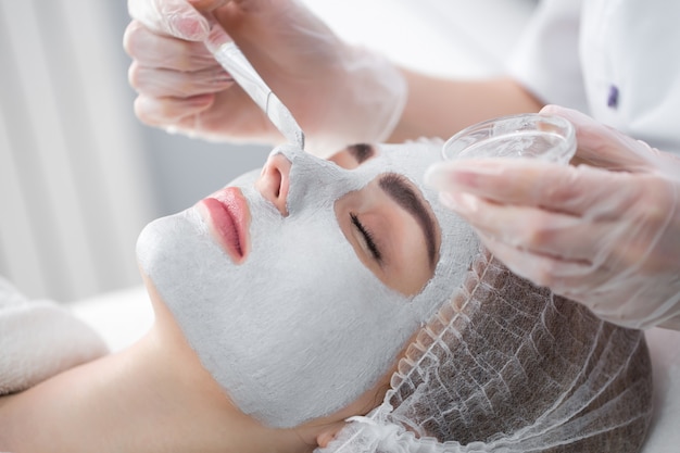 Photo face peeling mask, spa beauty treatment, skincare. woman getting facial care by beautician at spa salon