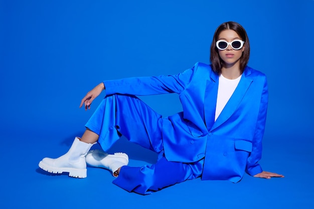 Photo fashion asian female model in blue suit white boots and sunglasses