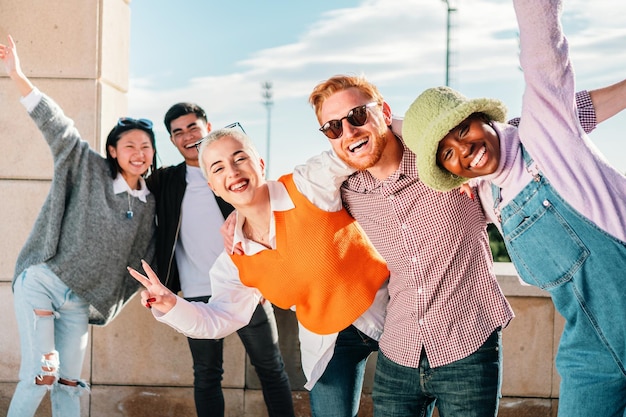 Фото Пятеро многонациональных друзей позируют перед камерой, улыбаются и веселятся вместе на открытом воздухе