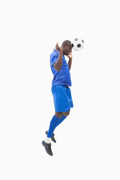 Футболист в синем заголовке мяча