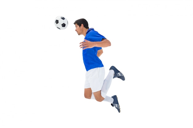 Фото Футболист в синем прыжке в мяч