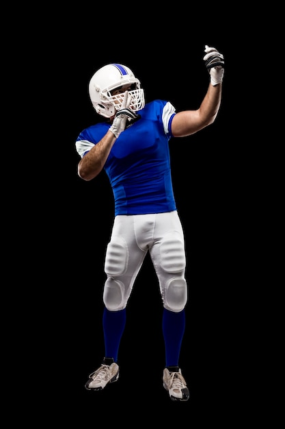 Photo football player with a blue uniform making a selfie on a black wall