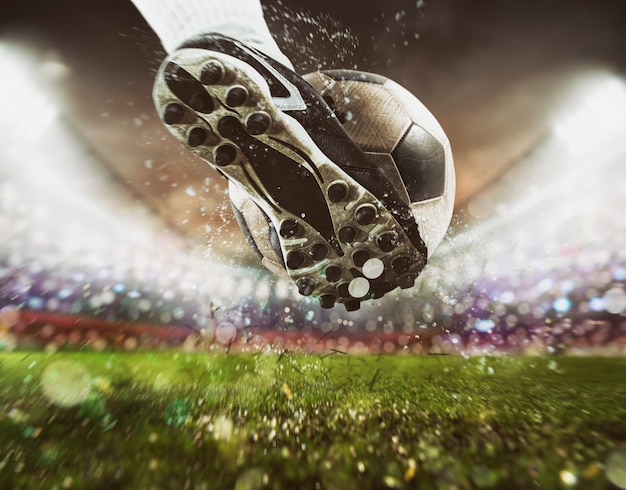 Photo football scene at night match with close up of a soccer shoe hitting the ball with power