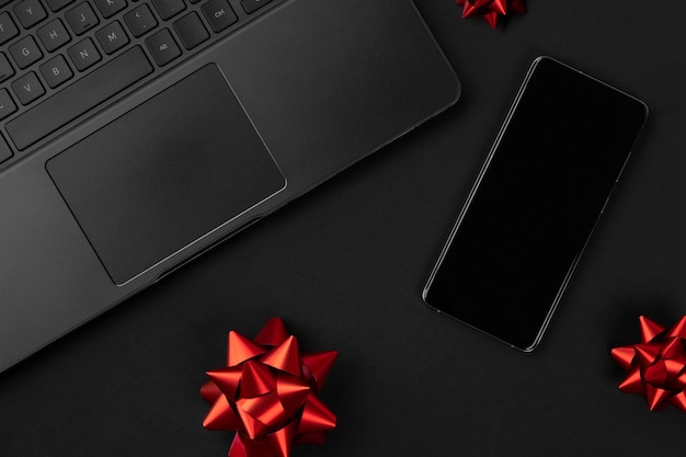Flat lay top view composition laptop smartphone and bow black friday sale mockup