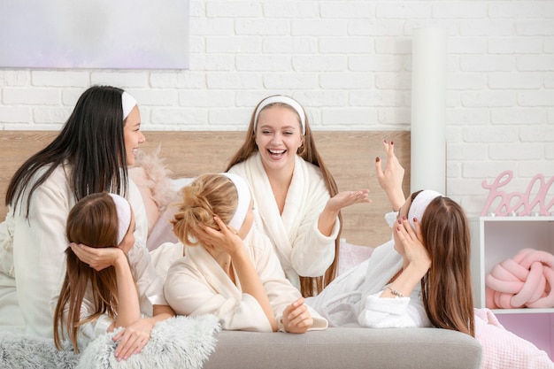 Gelukkige jonge vrouwen tijdens vrijgezellenfeest thuis